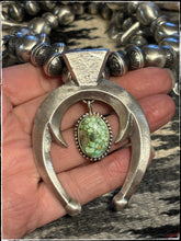 Load image into Gallery viewer, Navajo artists Ray Adakai (sandcast Naja) and Sophia Becenti (beads and blossoms) squash blossom necklace.  Close up of sand cast Naja and Sonoran Gold turquoise center drop. 
