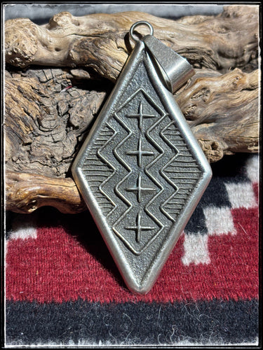 Stanford Yazzie, Navajo silversmith. Sterling silver tufa cast pendant. 