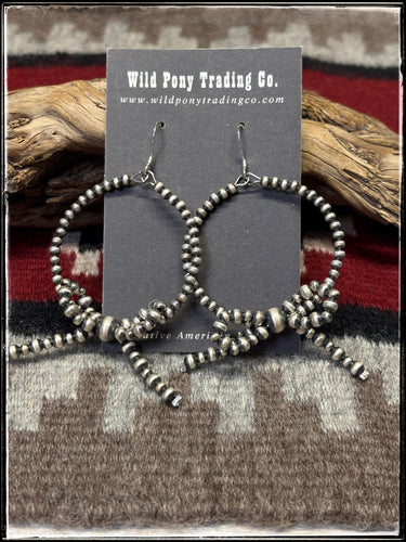 Sterling silver oxidized beads with a bow at the bottom of the hoop. 