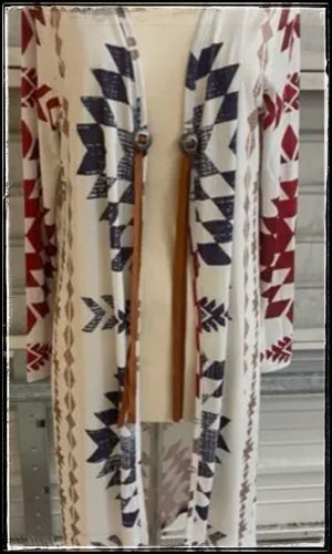 A cream, burgundy, and navy sweater in duster length with conchos and leather cord. 