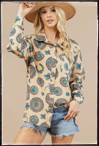 A long sleeve, button down blouse, covered in printed conchos, najas, and turquoise pieces. 