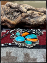 Load image into Gallery viewer, Augustine Largo, Navajo silversmith.  Sterling silver, Kingman turquoise stones, and orange spiny shell pieces set in a half cluster pattern. 
