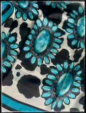 Load image into Gallery viewer, Black and white cow print with a turquoise cluster pattern and a turquoise border. 
