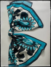 Load image into Gallery viewer, Black and white cow print with a turquoise cluster pattern and a turquoise border. 
