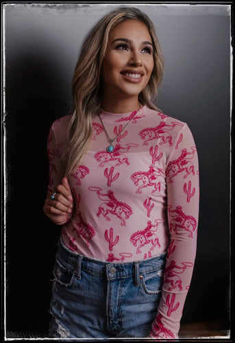 Pink sheer long sleeve top featuring broncs and cactus. 