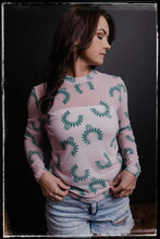 Load image into Gallery viewer, A pale pink sheer top with turquoise Naja prints. 
