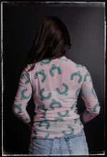 Load image into Gallery viewer, A pale pink sheer top with turquoise Naja prints. 
