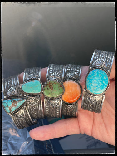 A group of sterling silver, hand stamped cuffs with turquoise stones from Navajo silversmith Sunshine Reeves.